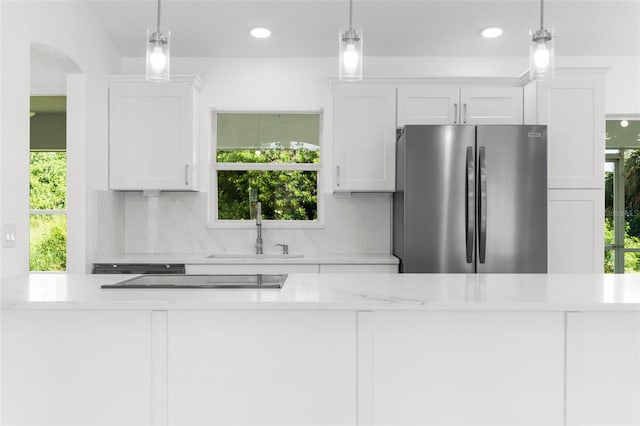 2399 Redstone Ave, North Port, FL 34288 - kitchen with freestanding refrigerator, black electric stovetop, white cabinetry, backsplash, and pendant lighting