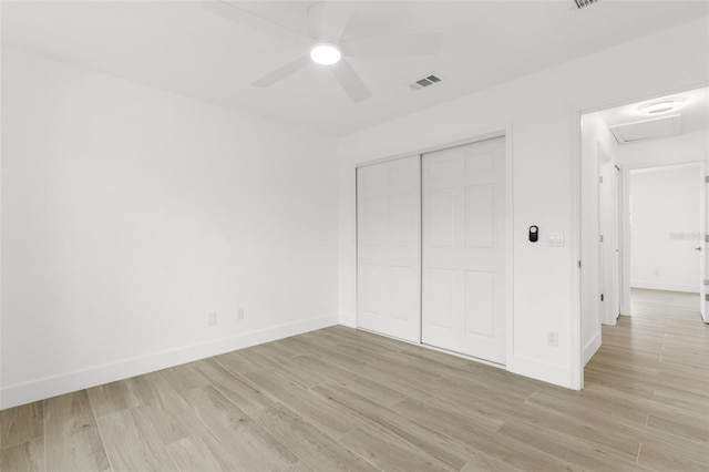 2399 Redstone Ave, North Port, FL 34288 - unfurnished bedroom with light wood finished floors, a closet, attic access, and a ceiling fan