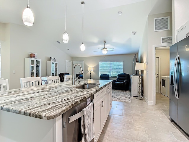5493 Jody Ave, North Port, FL 34288 - kitchen featuring refrigerator with ice dispenser, stainless steel dishwasher, white cabinets, lofted ceiling, and light stone counters