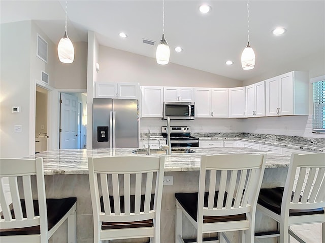 5493 Jody Ave, North Port, FL 34288 - kitchen with appliances with stainless steel finishes, lofted ceiling, white cabinetry, light stone countertops, and hanging light fixtures