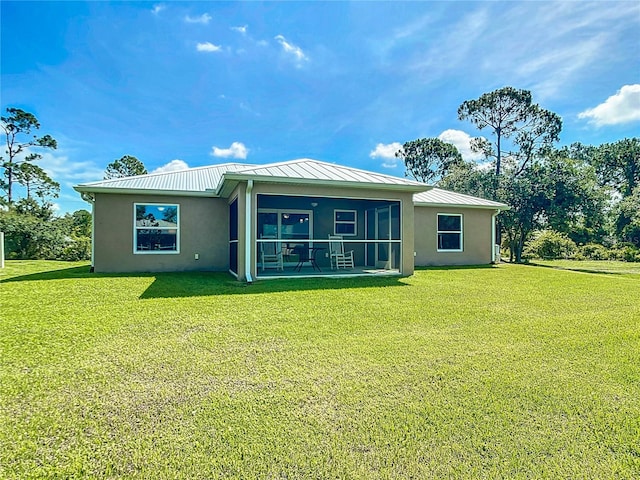 5493 Jody Ave, North Port, FL 34288 - rear view of house with stucco siding, a lawn, a standing seam roof, a sunroom, and a metal roof