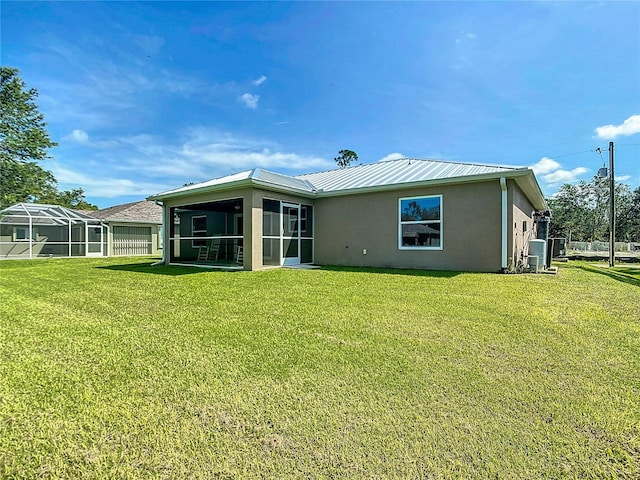 5493 Jody Ave, North Port, FL 34288 - rear view of house with stucco siding, a yard, a sunroom, and a metal roof