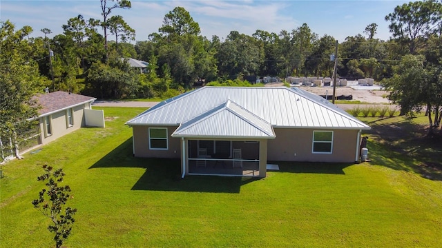 5493 Jody Ave, North Port, FL 34288 - rear view of property featuring a lawn, stucco siding, a sunroom, and a metal roof
