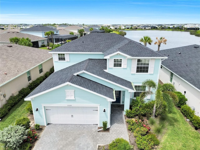 17395 Palmetto Pass Ln, Punta Gorda, FL 33982 - traditional-style home with a shingled roof, decorative driveway, a garage, a residential view, and a water view