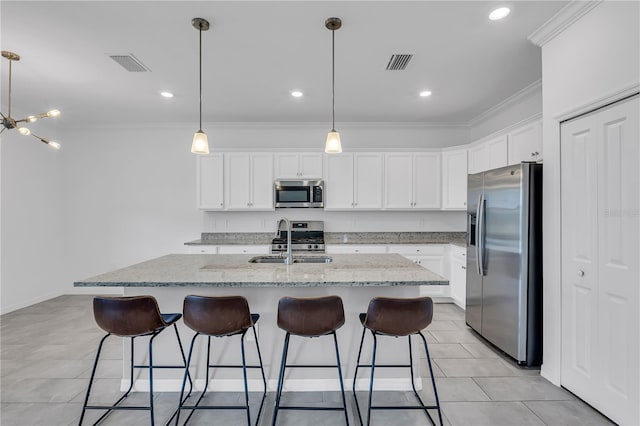 17395 Palmetto Pass Ln, Punta Gorda, FL 33982 - kitchen with stainless steel appliances, white cabinetry, ornamental molding, an island with sink, and a kitchen bar