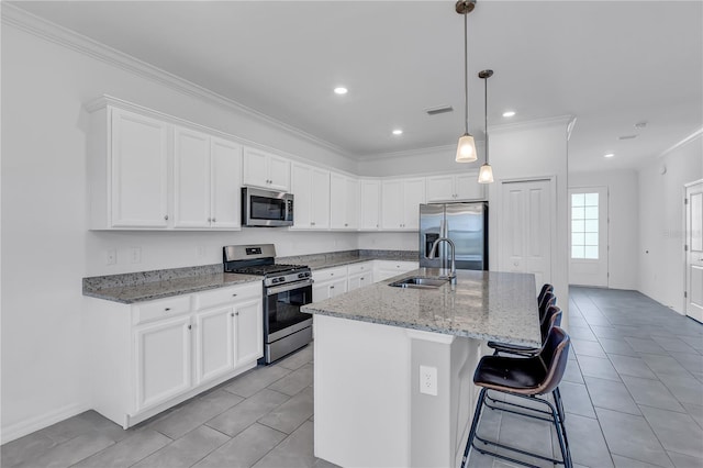 17395 Palmetto Pass Ln, Punta Gorda, FL 33982 - kitchen featuring stainless steel appliances, crown molding, light tile patterned flooring, an island with sink, and white cabinets