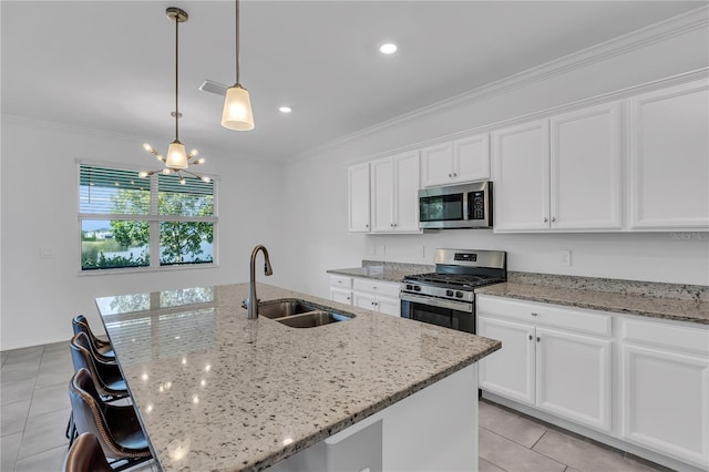 17395 Palmetto Pass Ln, Punta Gorda, FL 33982 - kitchen featuring stainless steel appliances, light tile patterned floors, a chandelier, an island with sink, and white cabinetry