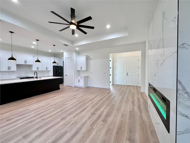 4748 Sylvania Ave, North Port, FL 34286 - unfurnished living room featuring a raised ceiling, a ceiling fan, light wood-style floors, and recessed lighting