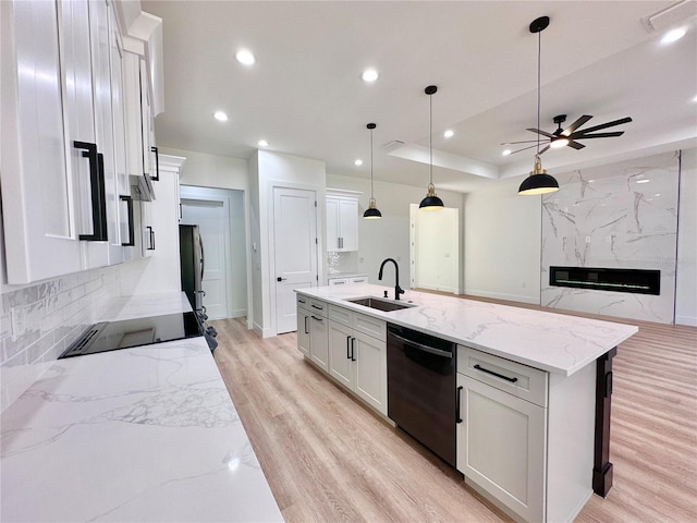 4748 Sylvania Ave, North Port, FL 34286 - kitchen with dishwasher, freestanding refrigerator, light wood-style flooring, ceiling fan, and a kitchen island with sink