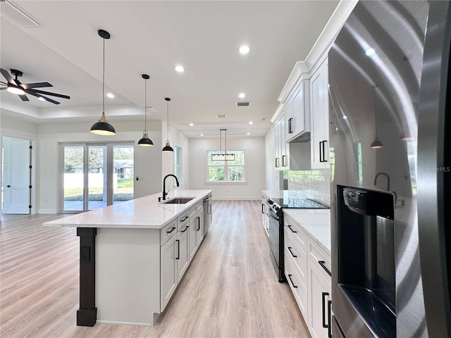 4748 Sylvania Ave, North Port, FL 34286 - kitchen with stainless steel appliances, light wood finished floors, an island with sink, white cabinetry, and recessed lighting