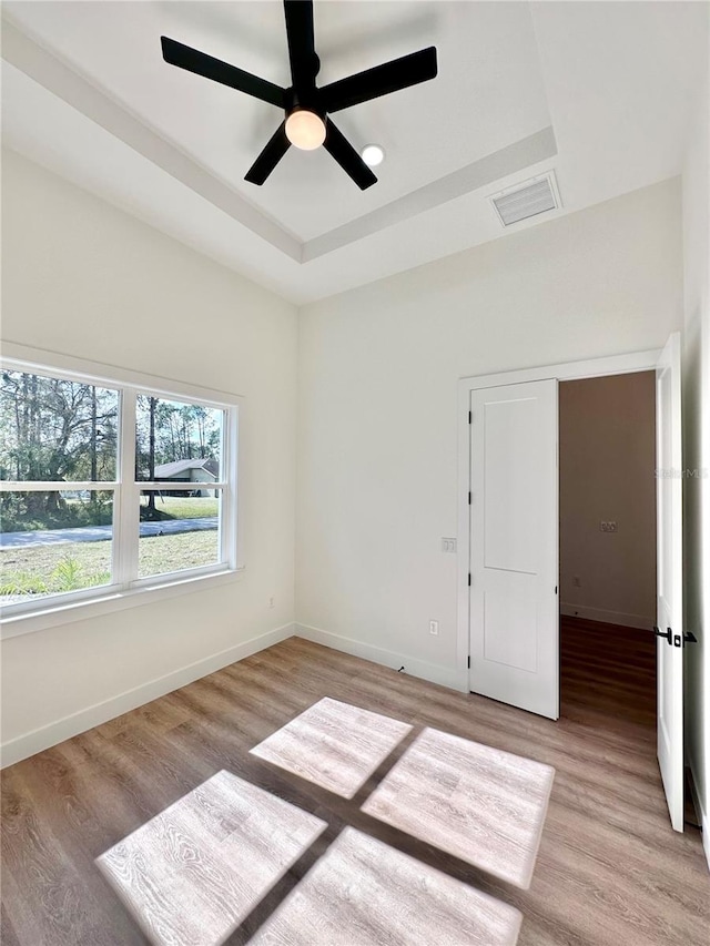 4748 Sylvania Ave, North Port, FL 34286 - unfurnished room featuring light wood finished floors, a raised ceiling, and a ceiling fan