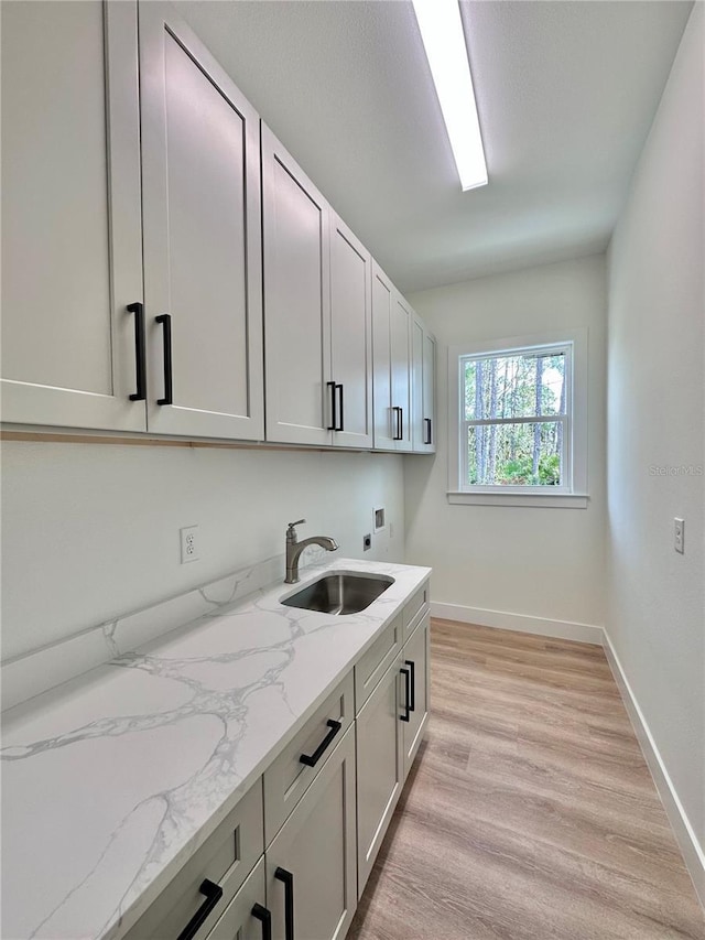 4748 Sylvania Ave, North Port, FL 34286 - laundry room with washer hookup, electric dryer hookup, cabinet space, and light wood-style flooring