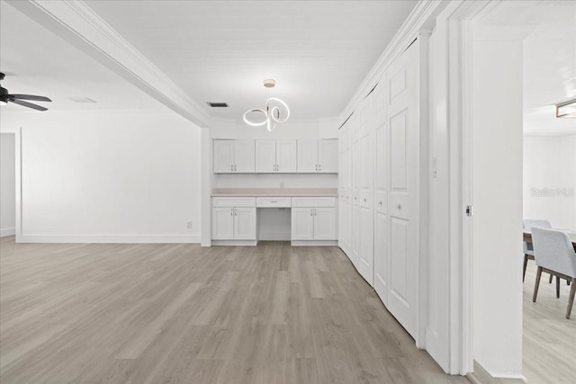 315 Durrance St, Punta Gorda, FL 33950 - kitchen with light wood-type flooring, white cabinets, ornamental molding, light countertops, and a ceiling fan