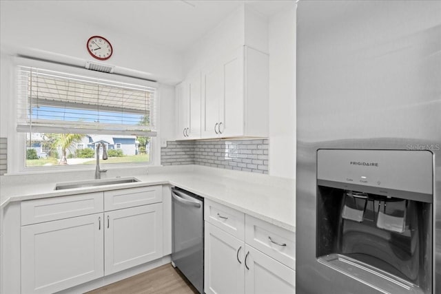 315 Durrance St, Punta Gorda, FL 33950 - kitchen with refrigerator with ice dispenser, dishwasher, white cabinets, light countertops, and decorative backsplash