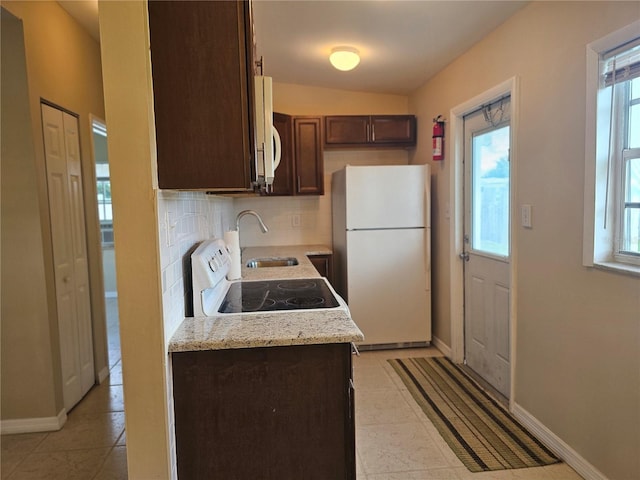 21552 Holdern Ave, Port Charlotte, FL 33952 - kitchen featuring white appliances, dark brown cabinets, healthy amount of natural light, decorative backsplash, and lofted ceiling