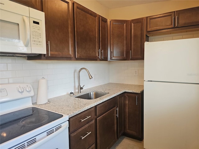 21552 Holdern Ave, Port Charlotte, FL 33952 - kitchen with white appliances, light stone counters, backsplash, and dark brown cabinets