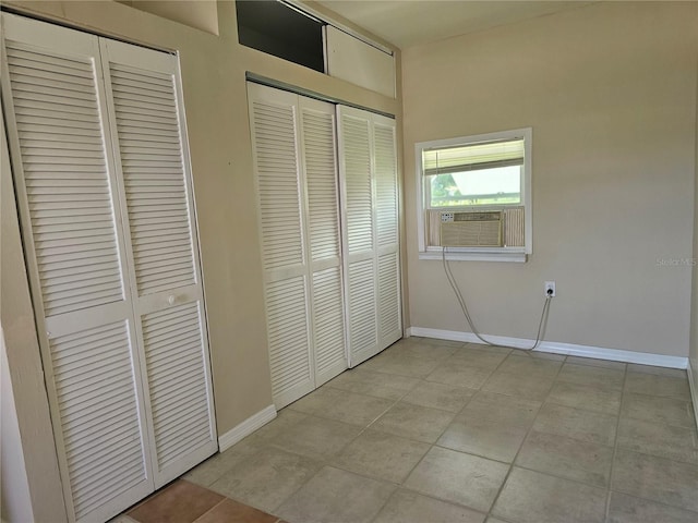 21552 Holdern Ave, Port Charlotte, FL 33952 - unfurnished bedroom featuring two closets, cooling unit, and light tile patterned floors