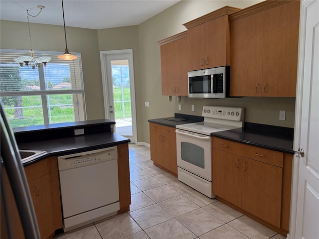 2760 Royal Palm Dr, North Port, FL 34288 - kitchen with white appliances, dark countertops, a chandelier, and pendant lighting