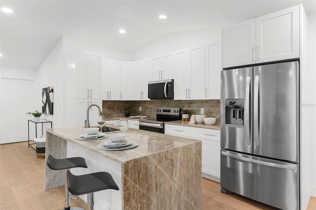 11772 96th Pl, Seminole, FL 33772 - kitchen featuring appliances with stainless steel finishes, backsplash, light wood-style floors, white cabinets, and recessed lighting