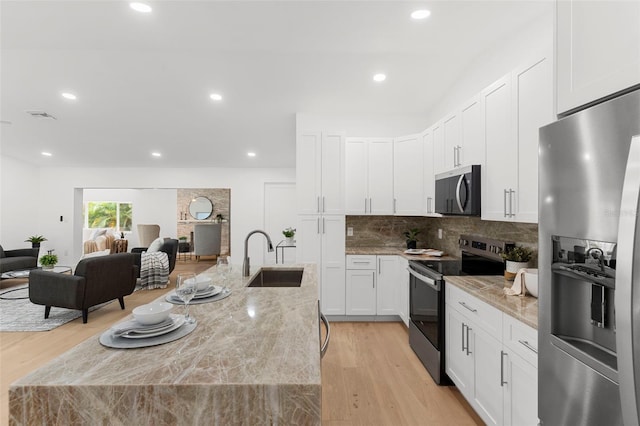11772 96th Pl, Seminole, FL 33772 - kitchen featuring appliances with stainless steel finishes, light wood-type flooring, decorative backsplash, white cabinetry, and recessed lighting