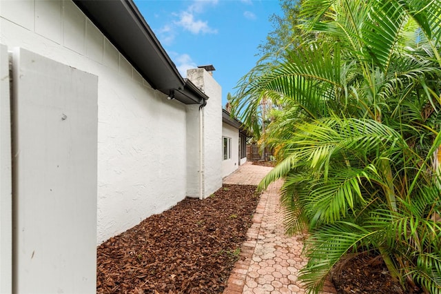 11772 96th Pl, Seminole, FL 33772 - view of side of home featuring a chimney and stucco siding