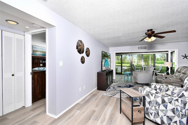 3 Pirates Ln Unit 32A, Punta Gorda, FL 33955 - living room featuring light wood finished floors, a textured ceiling, and ceiling fan