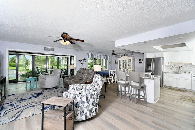 3 Pirates Ln Unit 32A, Punta Gorda, FL 33955 - living room featuring ceiling fan, light wood-style floors, and a textured ceiling