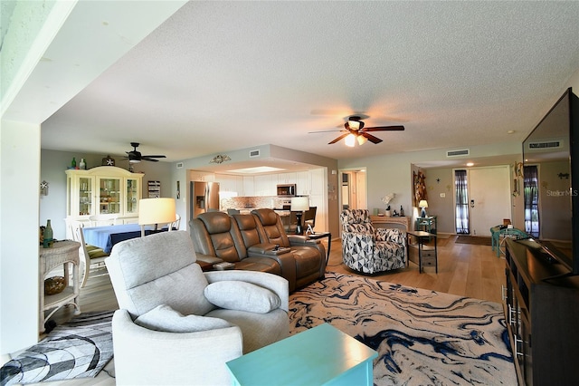 3 Pirates Ln Unit 32A, Punta Gorda, FL 33955 - living area featuring ceiling fan, light wood-style flooring, and a textured ceiling