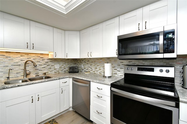3 Pirates Ln Unit 32A, Punta Gorda, FL 33955 - kitchen featuring stainless steel appliances, tasteful backsplash, light wood-style flooring, and white cabinets