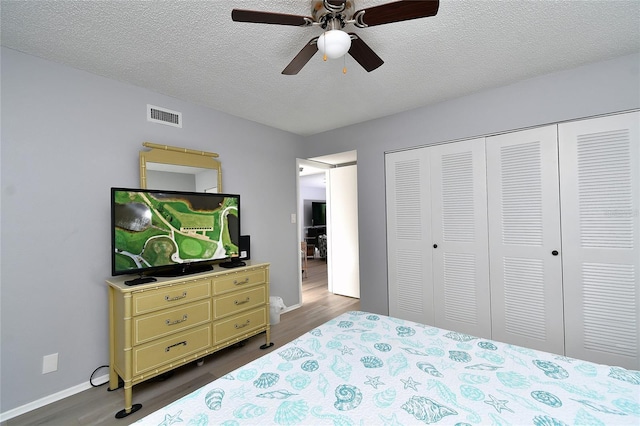 3 Pirates Ln Unit 32A, Punta Gorda, FL 33955 - bedroom featuring dark wood-type flooring, a closet, a textured ceiling, and a ceiling fan