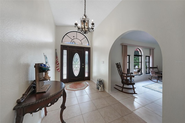 25499 Taltal Dr, Punta Gorda, FL 33983 - foyer entrance with arched walkways, a chandelier, tile patterned floors, and high vaulted ceiling