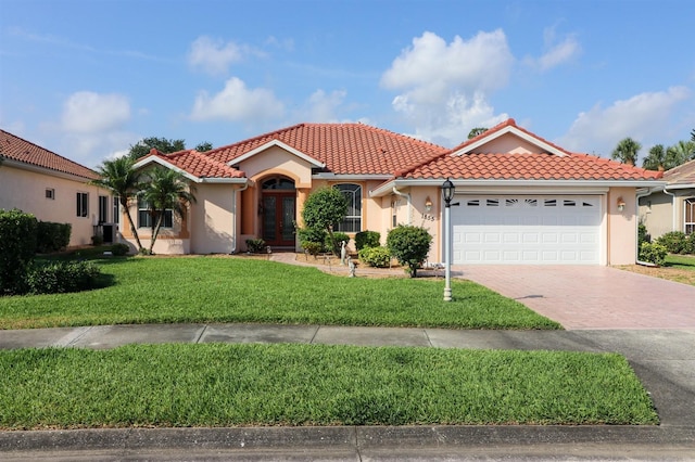 1855 Silver Palm Rd, North Port, FL 34288 - mediterranean / spanish house with french doors, a tile roof, stucco siding, decorative driveway, and an attached garage