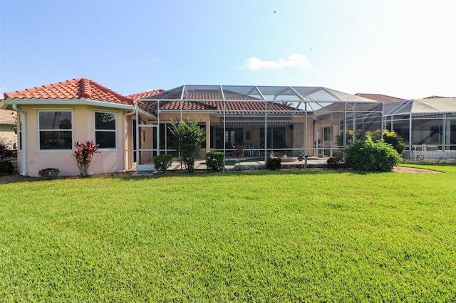 1855 Silver Palm Rd, North Port, FL 34288 - back of house with a lawn, stucco siding, a tiled roof, and glass enclosure