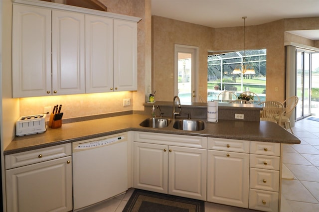 1855 Silver Palm Rd, North Port, FL 34288 - kitchen featuring dishwasher, a peninsula, light tile patterned flooring, white cabinetry, and dark countertops