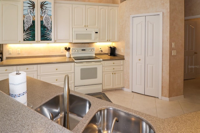 1855 Silver Palm Rd, North Port, FL 34288 - kitchen with white appliances, light tile patterned floors, and white cabinets