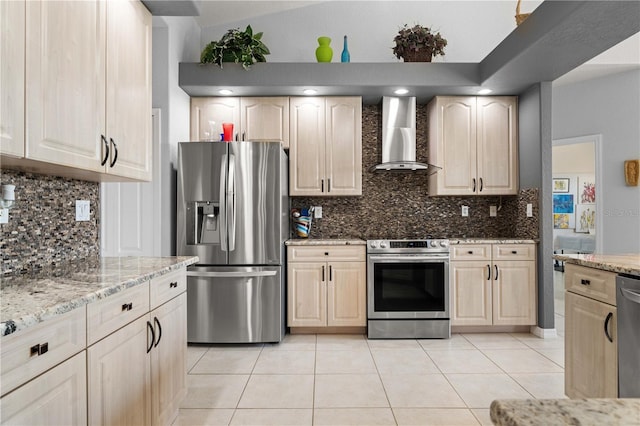 1422 Via Milanese, Punta Gorda, FL 33950 - kitchen featuring appliances with stainless steel finishes, wall chimney range hood, light tile patterned floors, light stone countertops, and light brown cabinets