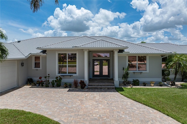 1422 Via Milanese, Punta Gorda, FL 33950 - ranch-style home featuring french doors, a tiled roof, an attached garage, driveway, and a front yard