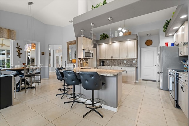 1422 Via Milanese, Punta Gorda, FL 33950 - kitchen with appliances with stainless steel finishes, light tile patterned floors, backsplash, light stone counters, and a towering ceiling