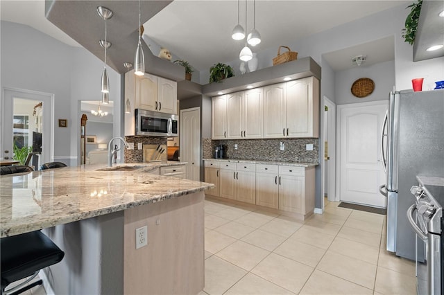 1422 Via Milanese, Punta Gorda, FL 33950 - kitchen with stainless steel appliances, decorative backsplash, light stone countertops, light tile patterned flooring, and a breakfast bar area