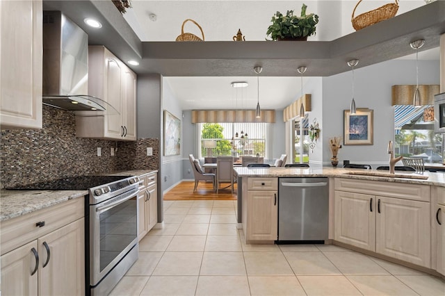 1422 Via Milanese, Punta Gorda, FL 33950 - kitchen with stainless steel appliances, wall chimney exhaust hood, light tile patterned flooring, decorative backsplash, and light stone countertops