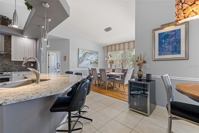 1422 Via Milanese, Punta Gorda, FL 33950 - kitchen with light tile patterned floors, light stone countertops, stainless steel oven, tasteful backsplash, and wine cooler