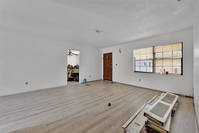 3207 Chariot Pl, Orlando, FL 32818 - unfurnished living room featuring light wood-type flooring, a ceiling fan, and a textured ceiling