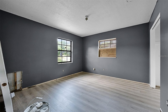 3207 Chariot Pl, Orlando, FL 32818 - unfurnished bedroom featuring multiple windows, wood finished floors, and a textured ceiling