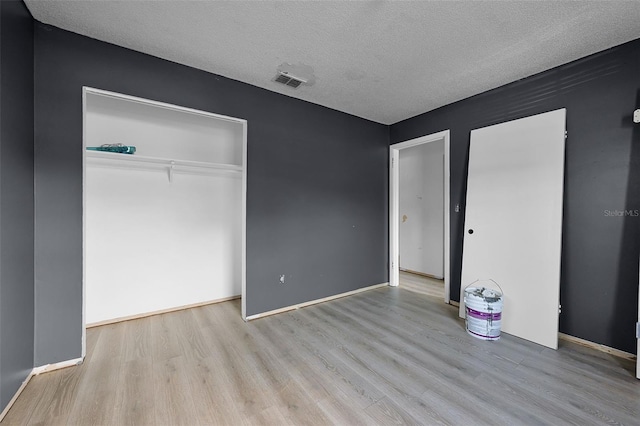 3207 Chariot Pl, Orlando, FL 32818 - unfurnished bedroom featuring wood finished floors, a textured ceiling, and a closet