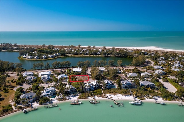 drone / aerial view with a water view and a beach view