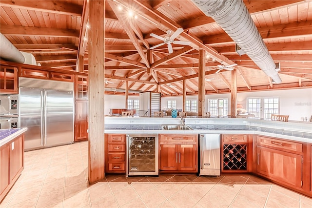 interior space with stainless steel appliances, beverage cooler, wood ceiling, and light tile patterned floors