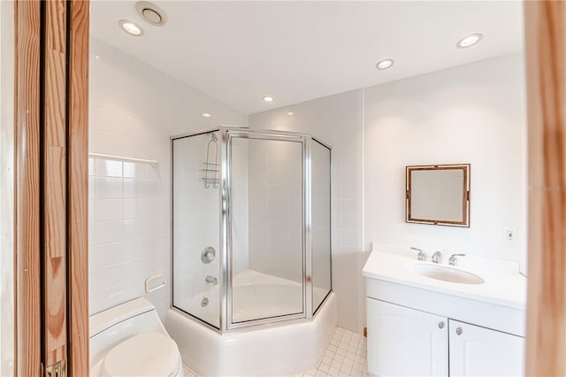 full bathroom with tile patterned flooring, enclosed tub / shower combo, toilet, vanity, and tile walls