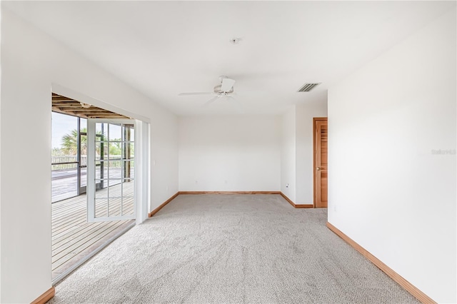 spare room featuring light colored carpet and ceiling fan