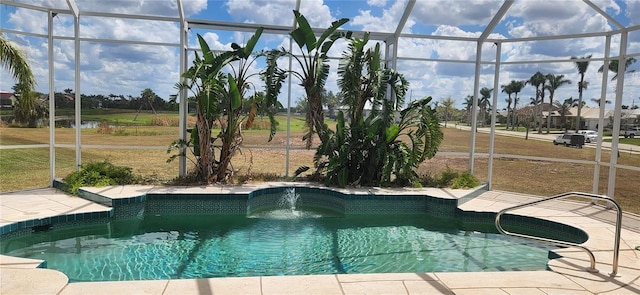 view of pool featuring pool water feature, a yard, and glass enclosure