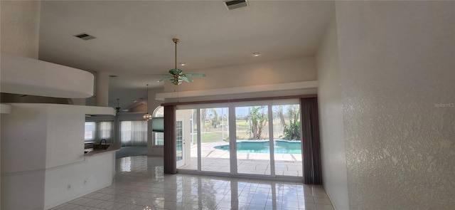 unfurnished living room with ceiling fan and light tile patterned floors